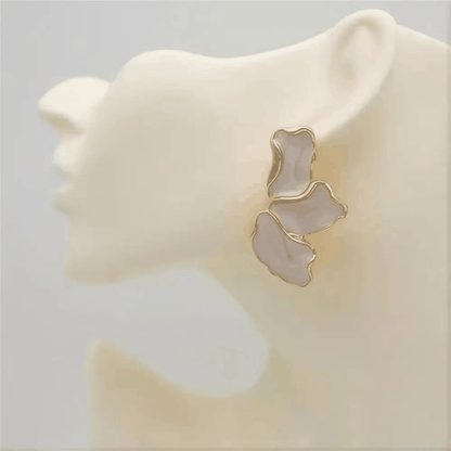 Boucles d’oreilles fleur dorées en métal, ornées de trois pétales blancs nacrés aux contours irréguliers