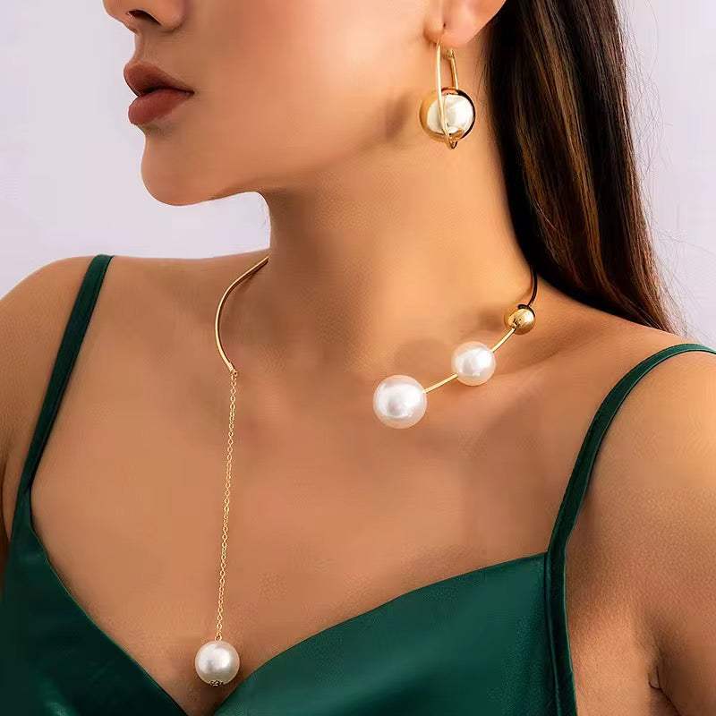 collier asymétrique doré en métal avec perles blanches nacrées et boucle d’oreille assortie