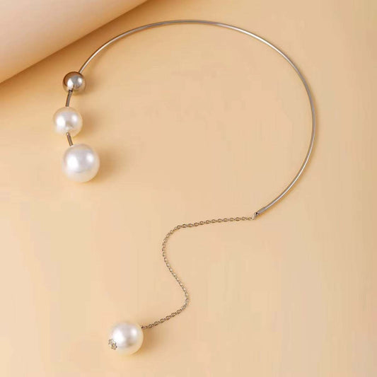 Collier asymétrique doré en métal fin, orné de perles blanches nacrées de tailles variées