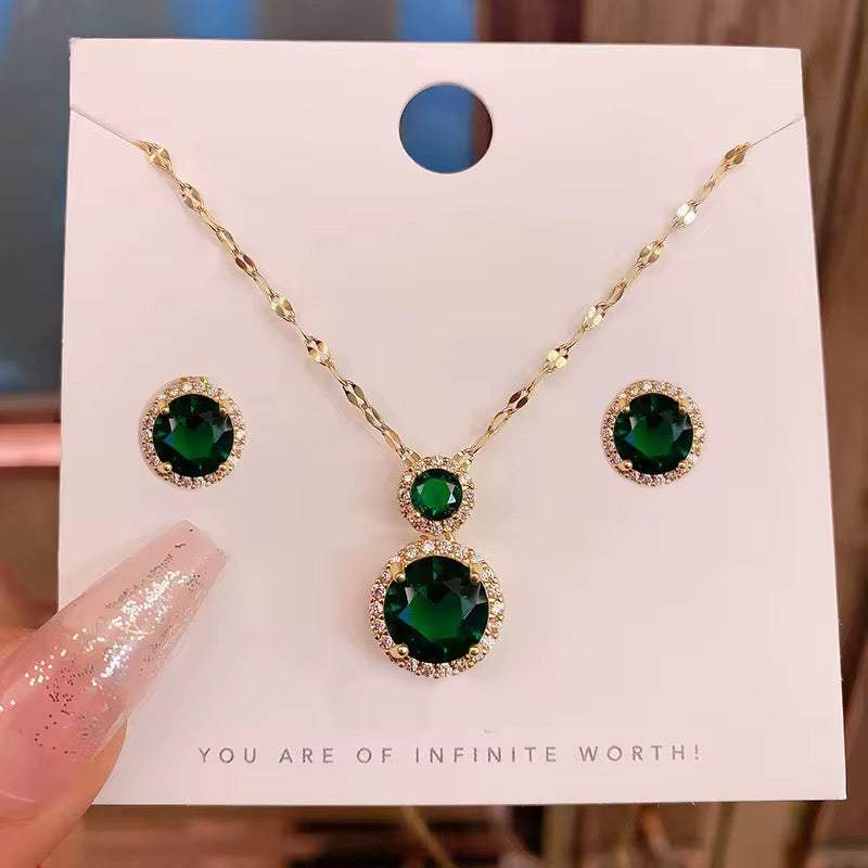 parure femme dorée avec collier et boucles d’oreilles dorés, ornés de pierres vert émeraude