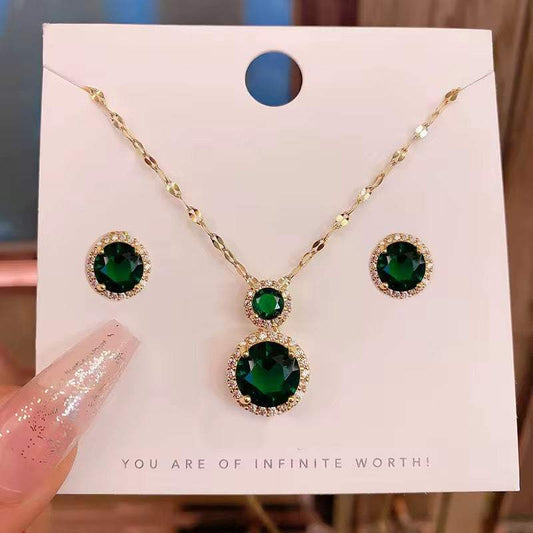 parure femme dorée avec collier et boucles d’oreilles dorés, ornés de pierres vert émeraude