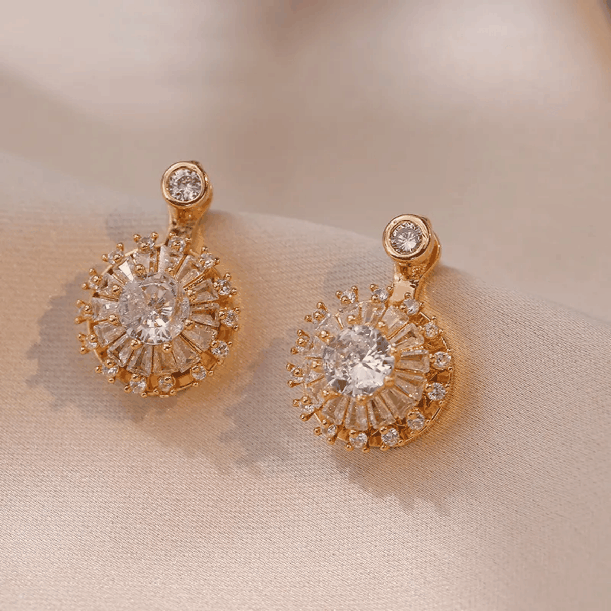 Parure feuille dorée composée de boucles d’oreilles dorées ornées de cristaux ronds et carrés scintillants