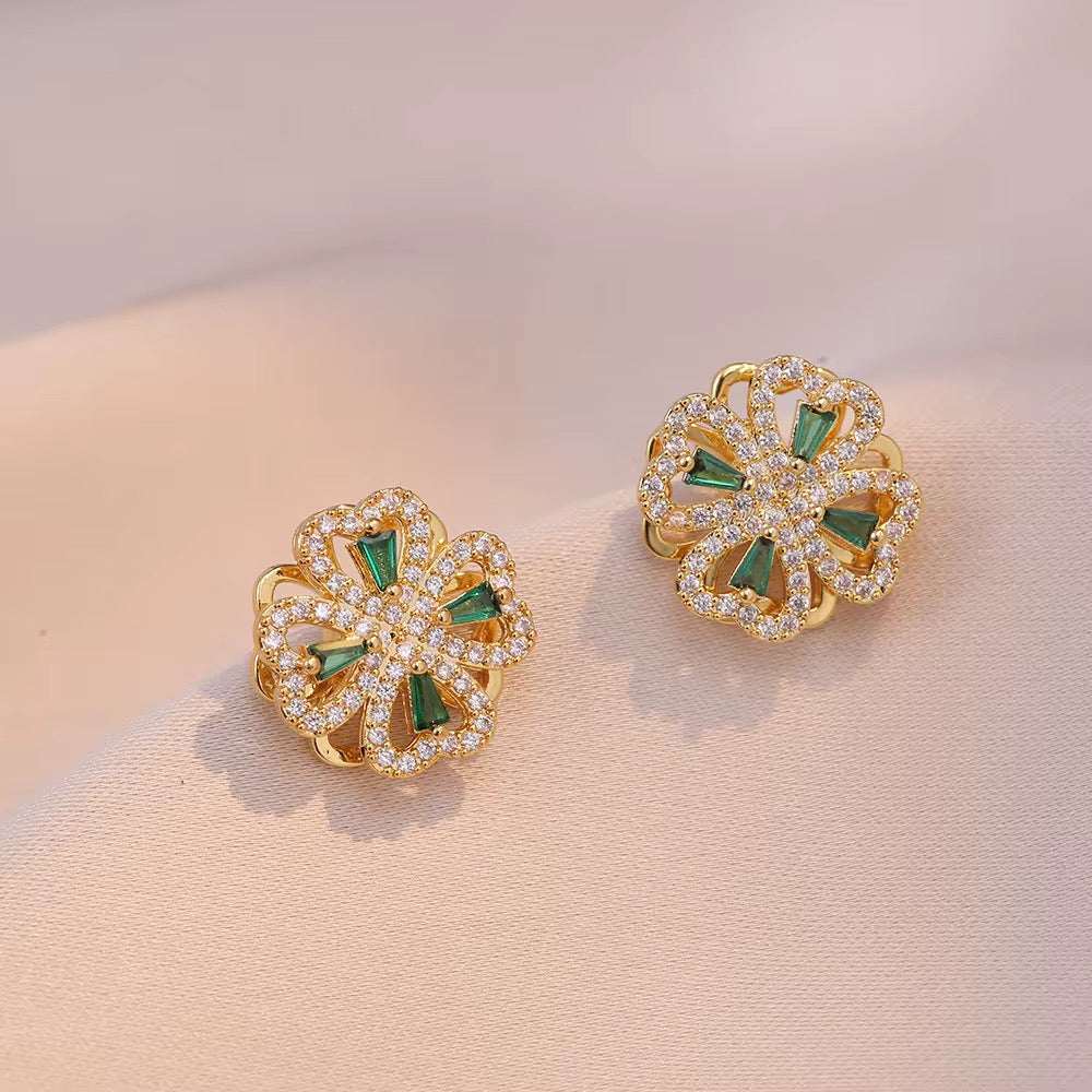 parure fleurs dorée composée de deux boucles d’oreilles dorées en forme de fleurs, ornées de cristaux et de détails verts