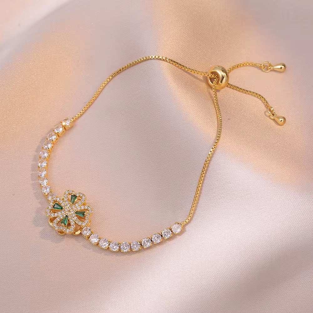 Parure fleurs dorée en acier titane, collier visible avec motif floral serti de pierres brillantes et détails verts